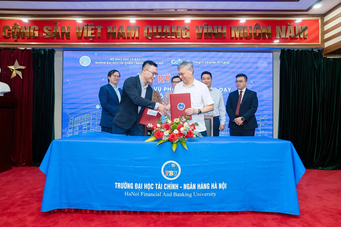 FBU and Co-EDU representatives exchange signed documents at the ceremony